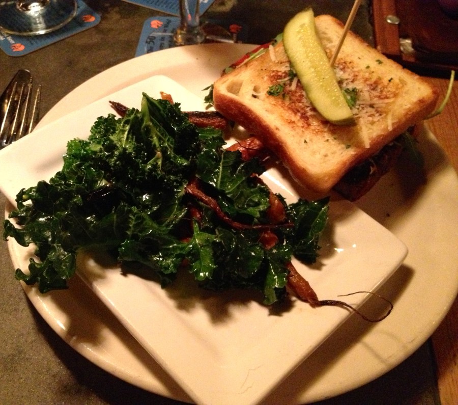 Meat loaf sandwich with a healthy side of kale and carrots.